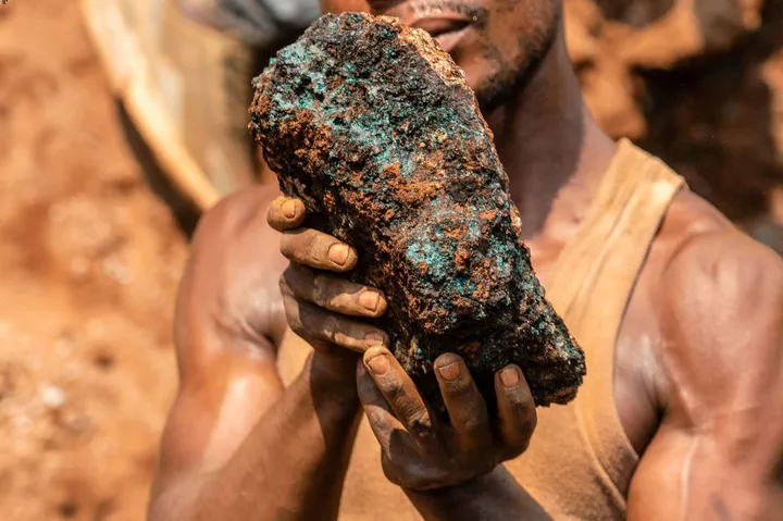 an artisanal miner, holds a cobalt stone at the Shabara artisanal mine